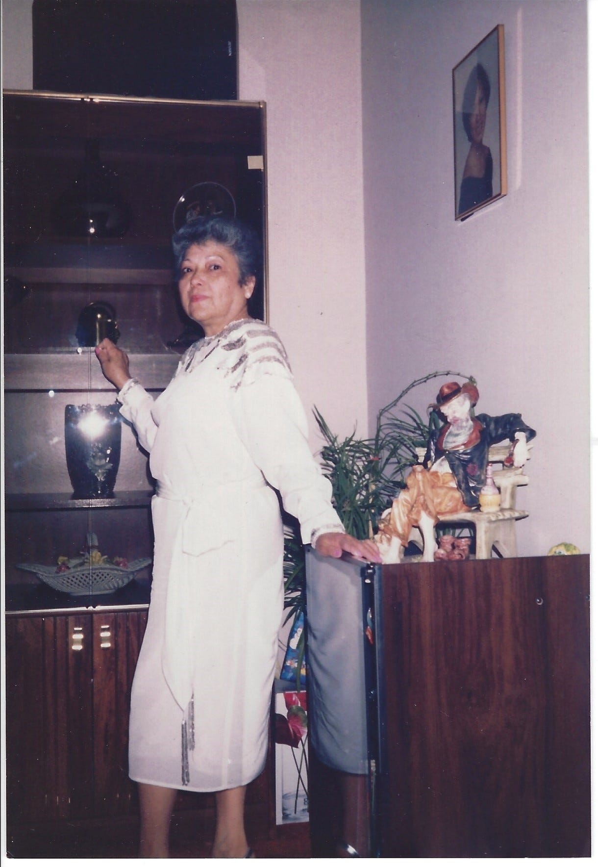 Grandma posing in her living room while standing next to the hobo statue.