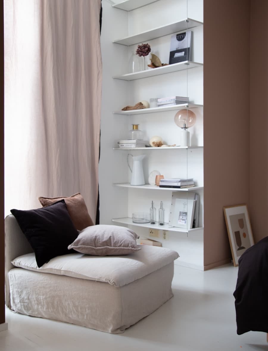 bedroom corner with white corner unit with shelves and warm neutral accessories