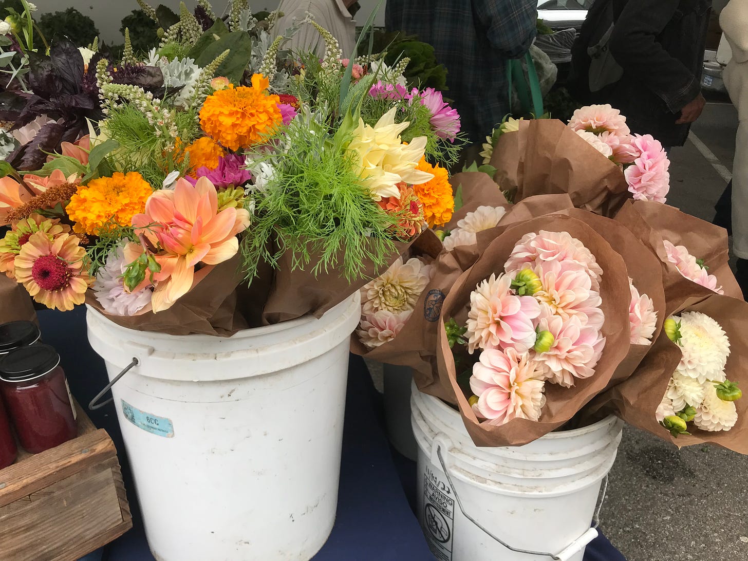 two white plastic buckets full of bouquets