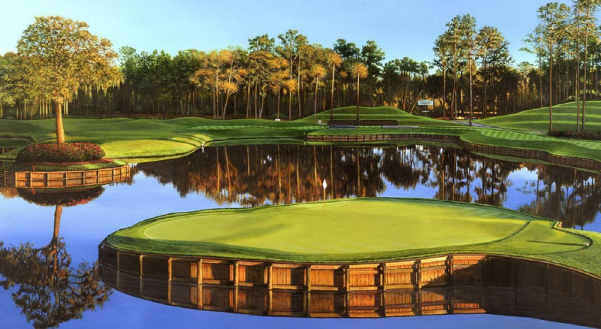 A scenic golf hole featuring an island green surrounded by water, with wooden bulkheads and lush trees in the background reflecting in the still water.