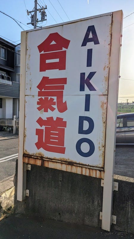 A sign saying "aikido" in Japanese and English