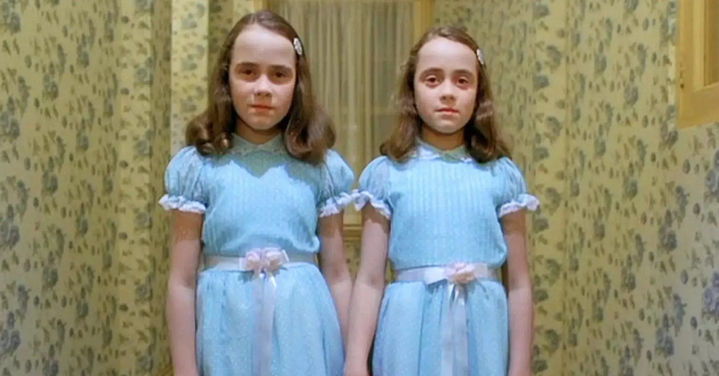 The twin girls in their blue dresses in a film still from The Shining.