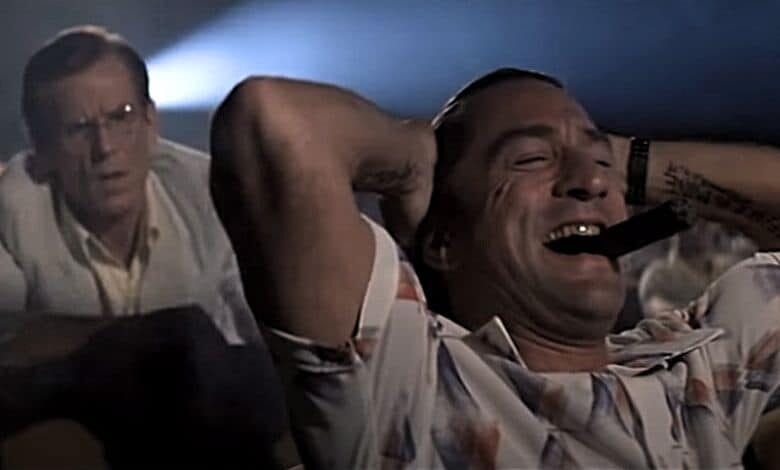 A scene from the movie Cape Fear showing the main character smoking a cigar in movie theater