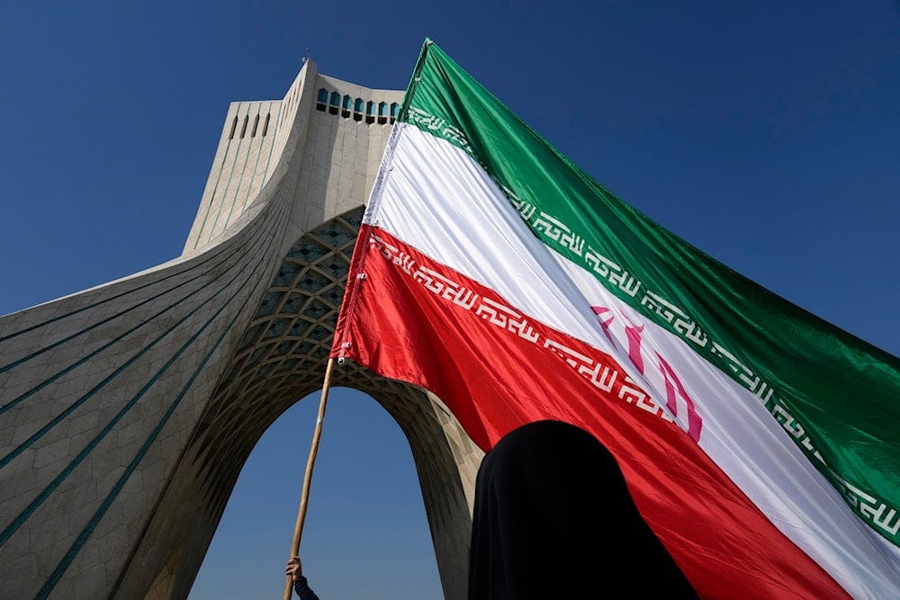 A huge Iranian flag is carried under the Azadi (Freedom) monument tower during the annual rally commemorating Iran's 1979 Islamic Revolution in Tehran, Iran, Sunday, Feb. 11, 2024 (AP) A huge Iranian flag is carried under the Azadi (Freedom) monument tower during the annual rally commemorating Iran's 1979 Islamic Revolution in Tehran, Iran, Sunday, Feb. 11, 2024 (AP)