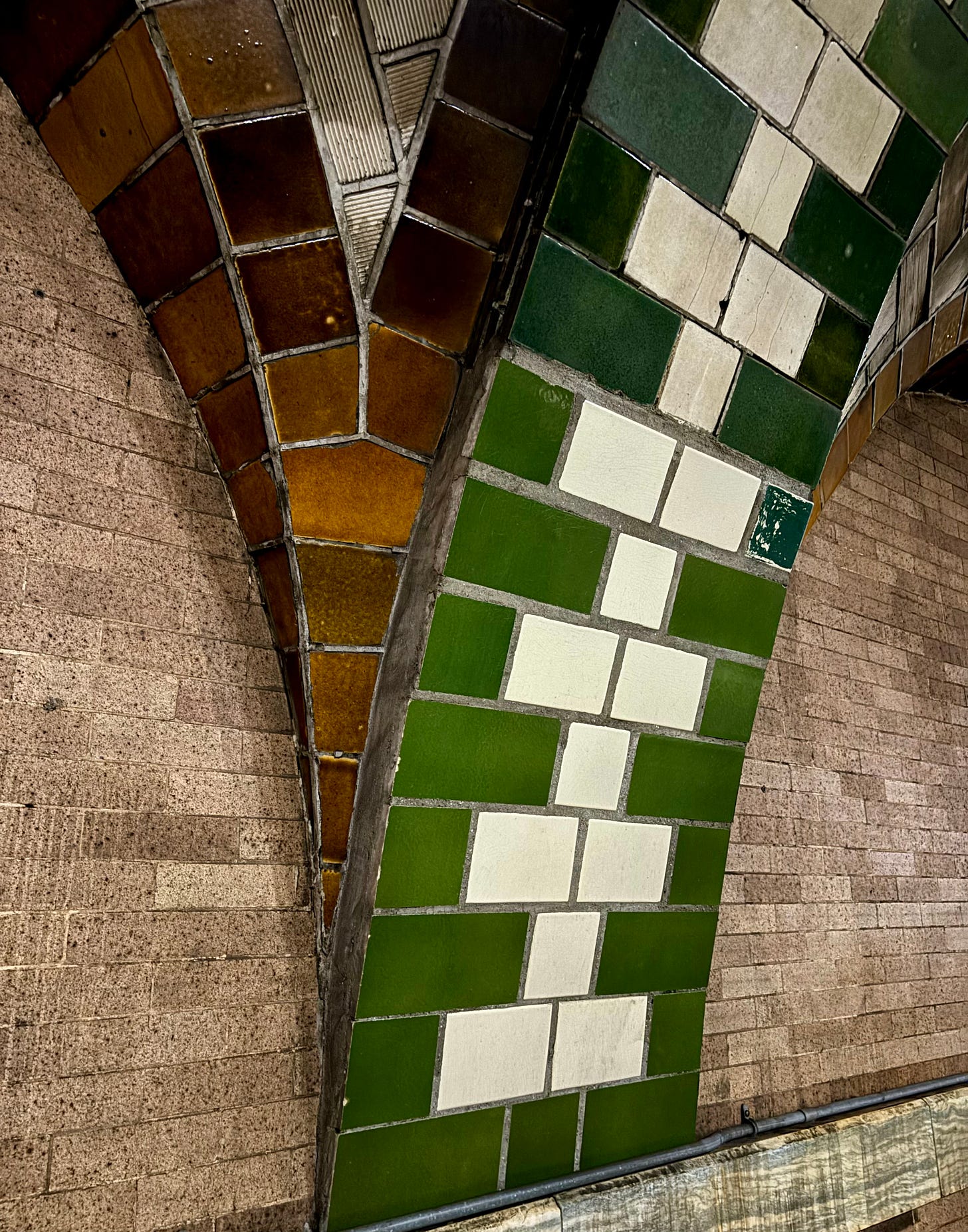 Green and amber tiles meet at the bottom corner of the vaulted arch.