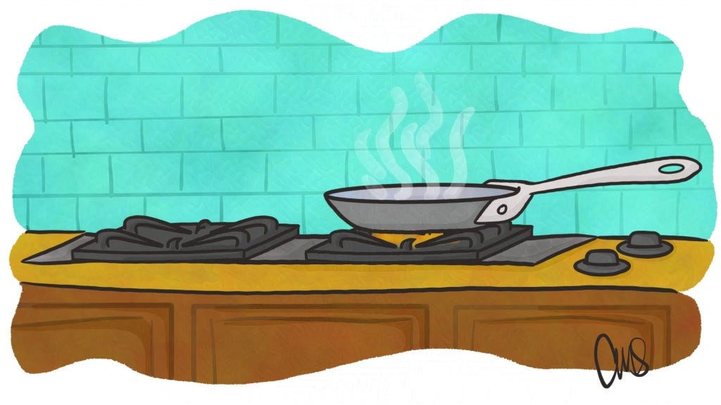 Stovetop in a kitchen, with right burner lit and nonstick frying pan on top cooking something.