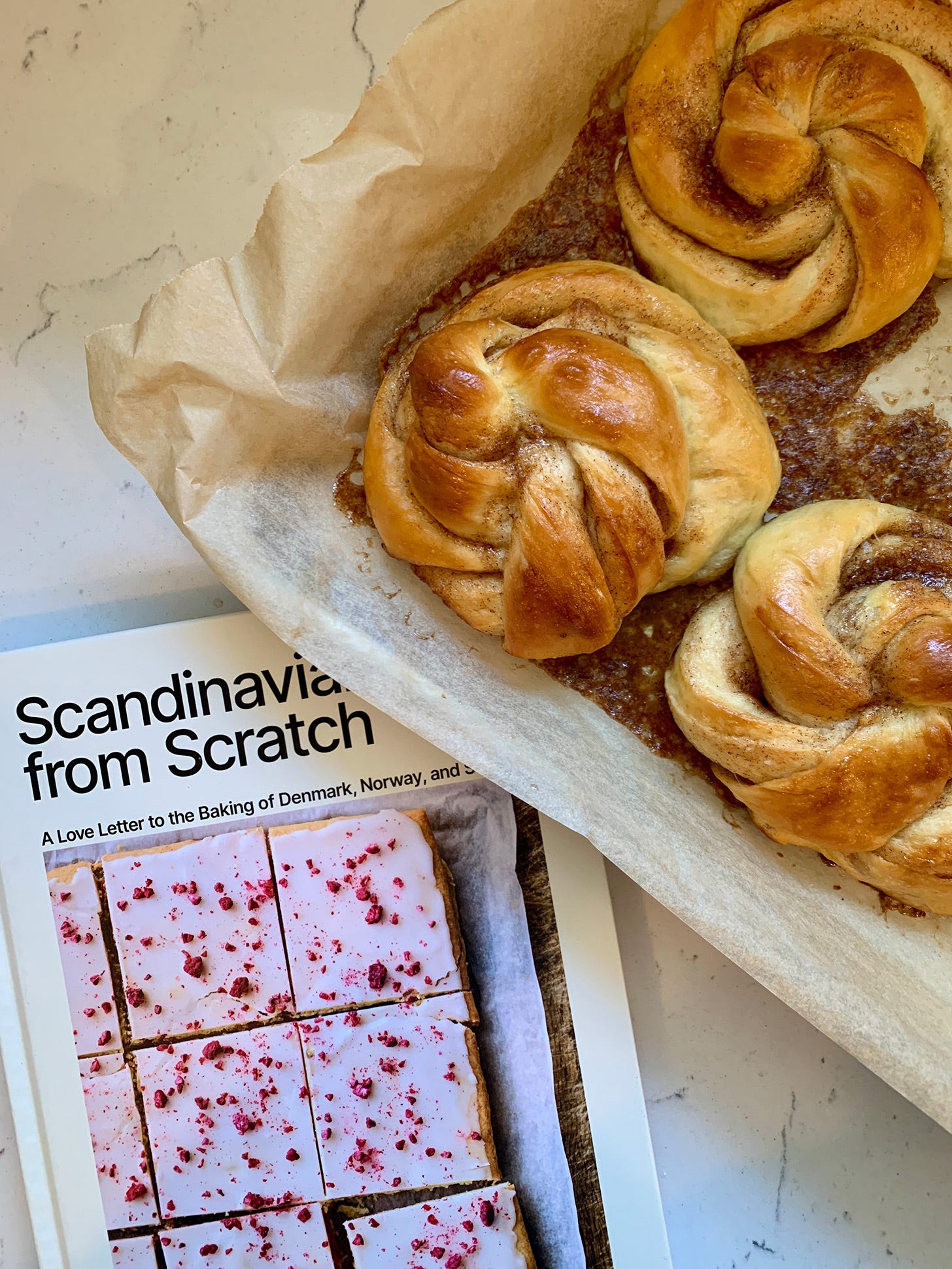 Photo of Swedish cinnamon knots beside Scandinavian From Scratch cookbook