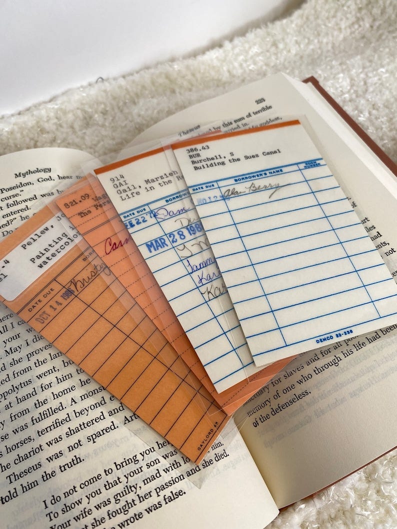 May include: Four library card pockets with orange and white borders. The top pocket has the text '386.43 BUR Burchell, S Building the Suez Canal' and the borrower's name is 'Alan Berry'. The second pocket has the text '914 GAI Gail, Marzieh Life in the R' and the date due is 'E22 Dam'. The third pocket has the text '821.09 The Pers' and the date due is 'DCT 14 1985 Misty Can'. The fourth pocket has the text 'MAR 28 198 Damm Kar Ka'.