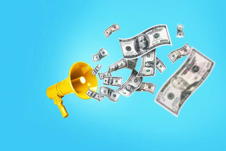 Dollar Money is flying in from the Golden yellow speaker on a blue background, a concept. Jackpot winning, creative idea. Bucks are floating. Successful business and economic development. Bonus