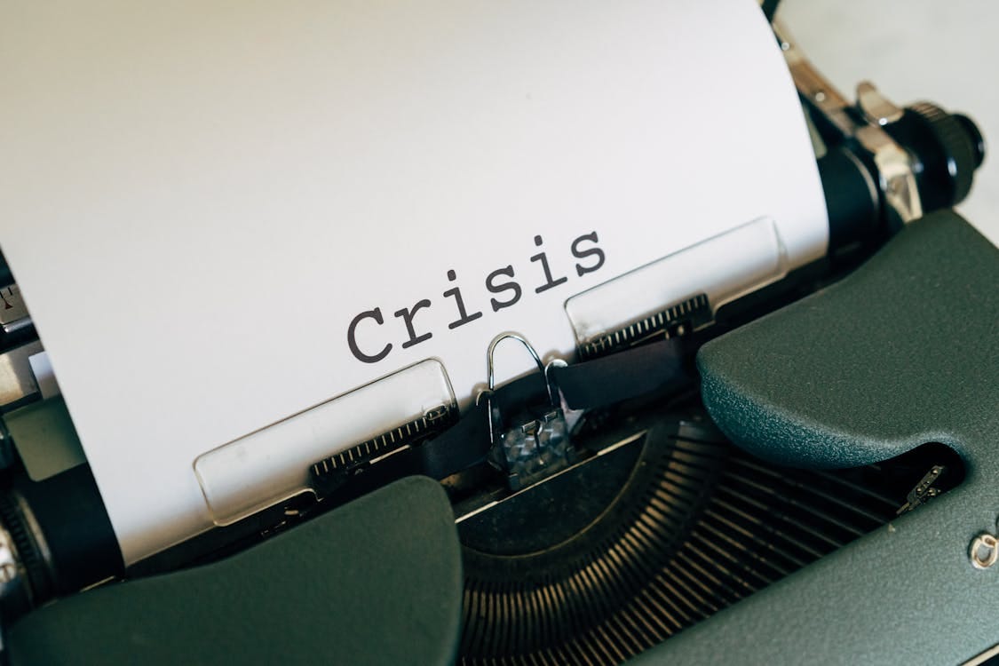 Free Close-up of a vintage typewriter with the word 'Crisis' typed on paper. Stock Photo