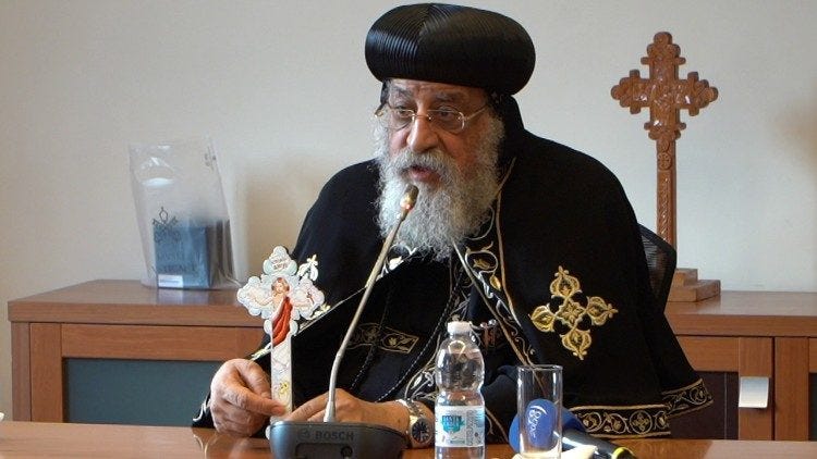 Pope Tawadros holds up a cross to help explain the steps of ecumenical dialogue 