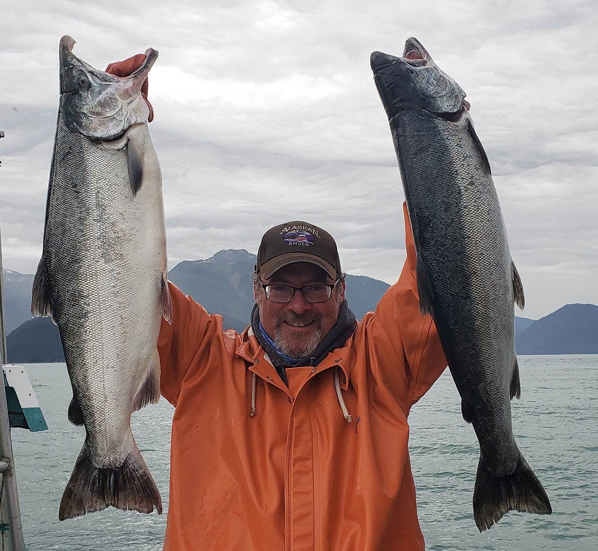 Hank Shaw holding up two coho salmon.