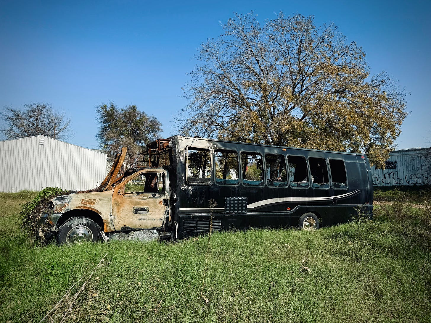 Burned out shuttle bus on an empty lot