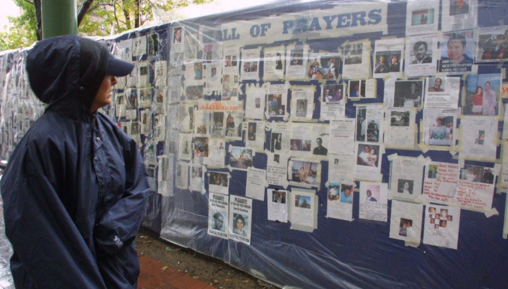 A woman looks at missing person posters of victims of the September 11 terrorist attacks on the World Trade Center in New York City on Sept. 14, 2001.(AP Photo/Robert Spencer)