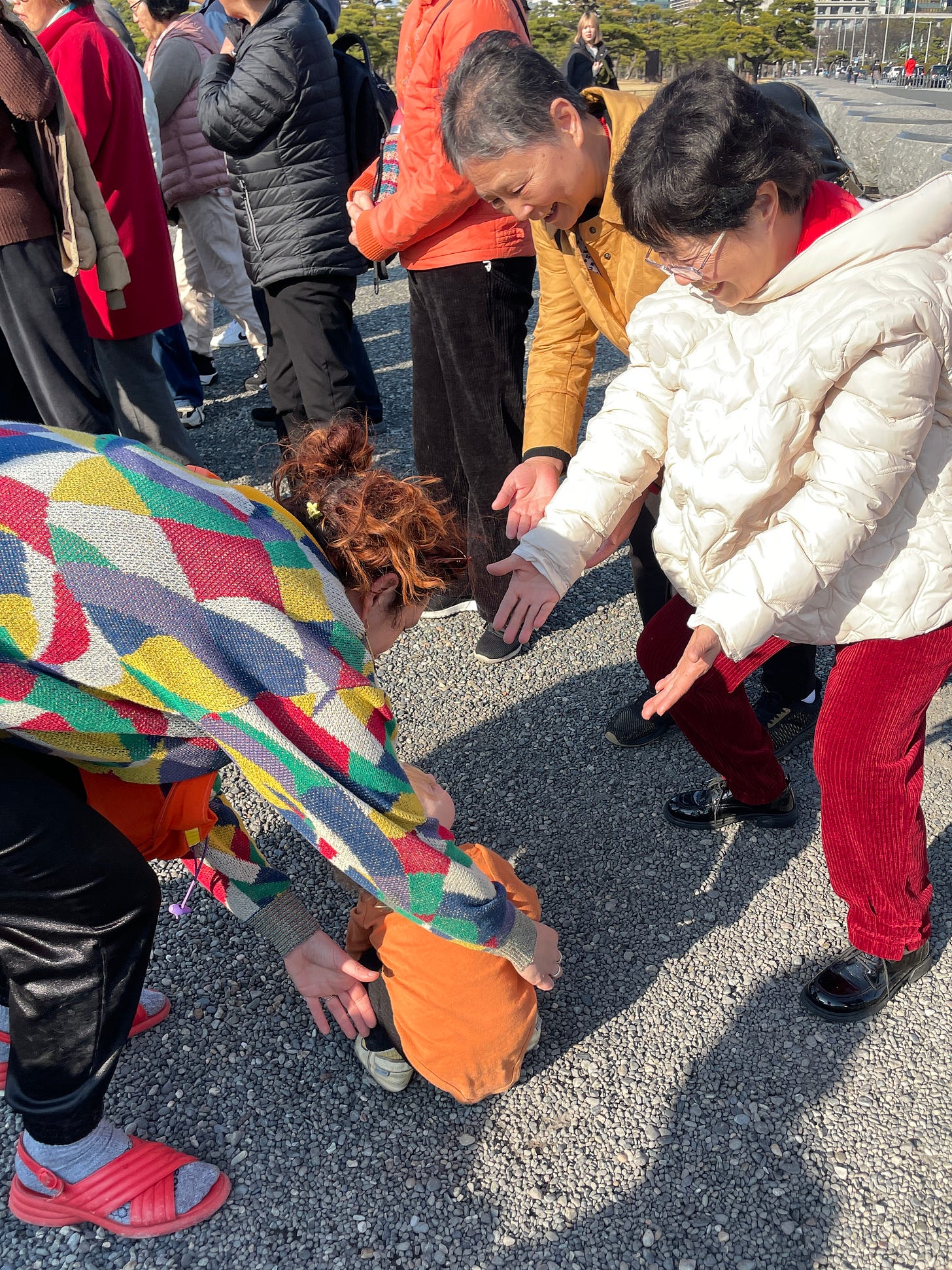 Japanese women fawn over baby Zulal at a tourist site.