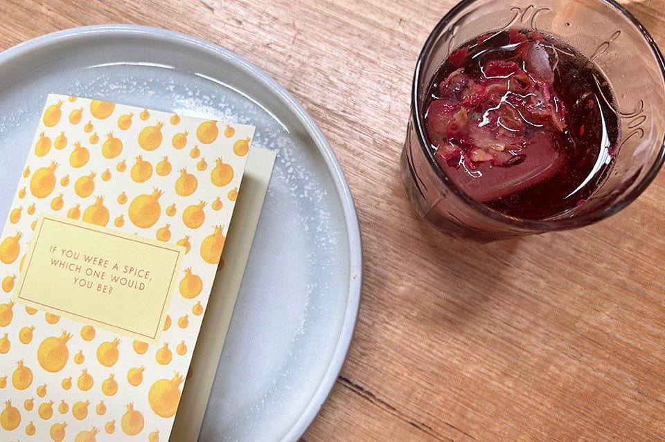 A rose-flavoured mocktail with a card that reads 'If you were a space, which one would you be?'.