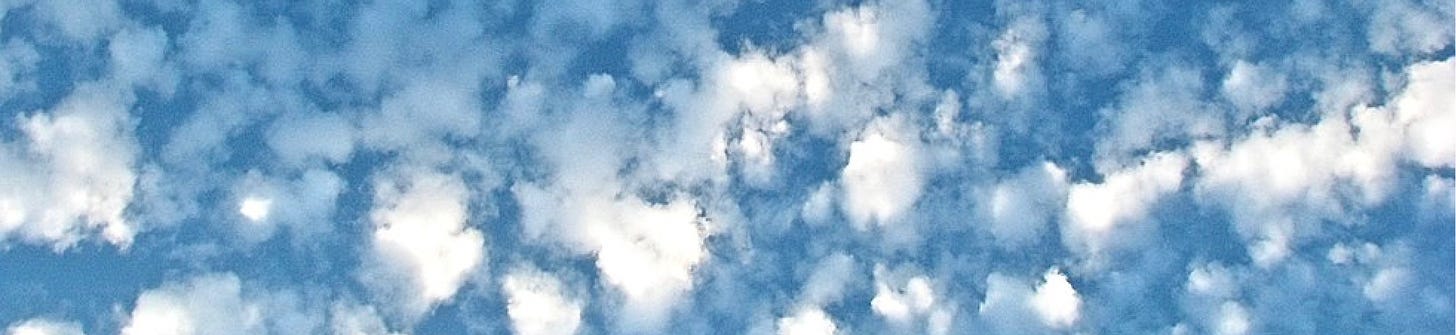 A scattering of small white cumulus clouds in the blue sky.