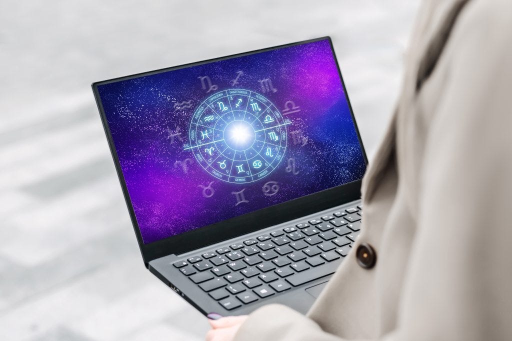 laptop in women's hands with purple screen and an astrological chart in turqoise