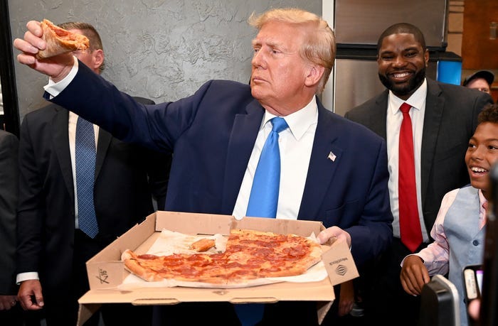 Former President Donald Trump and Florida congressman Byron Donalds receiving their order from Downtown House of Pizza in Downtown Fort Myers, after speaking at the Lee County Republican dinner in Fort Myers, Fla., Friday, April 21, 2023. (
