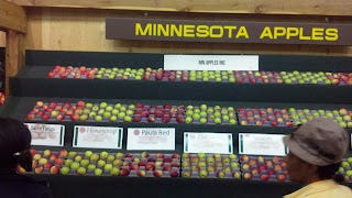 A large stand of apples in different colors and sizes that says Minnesota Apples at the top.