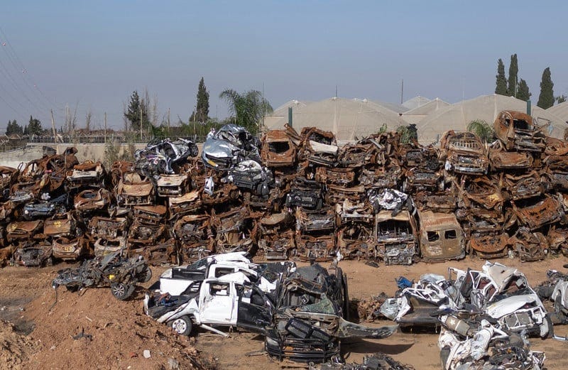 Dozens of destroyed cars and vans sitting in an open lot