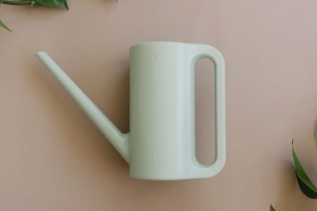 flat lay product photo of modern plastic watering can