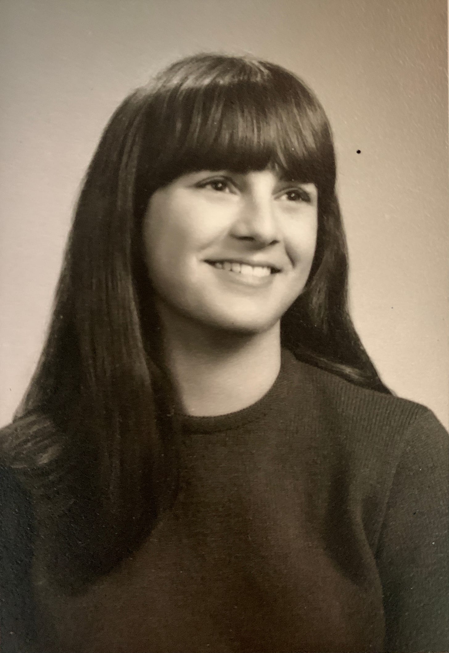 High school graduation photo of a girl with long dark hair and a nice smile