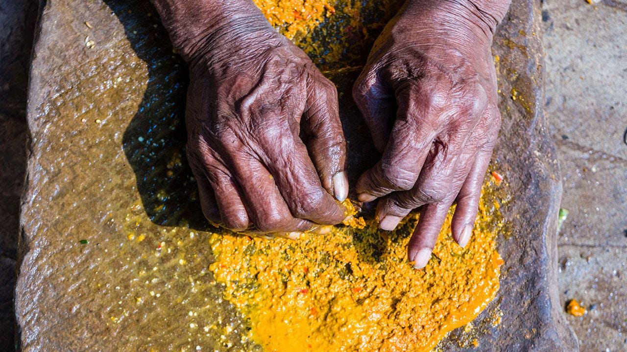 A woman grinding spices in India