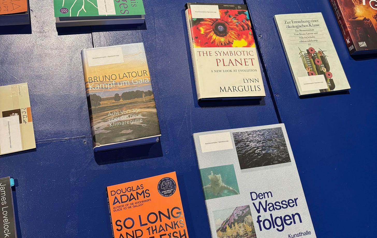 books on a blue table. One of them is "the symbiotic planet" by Lynn Margulis