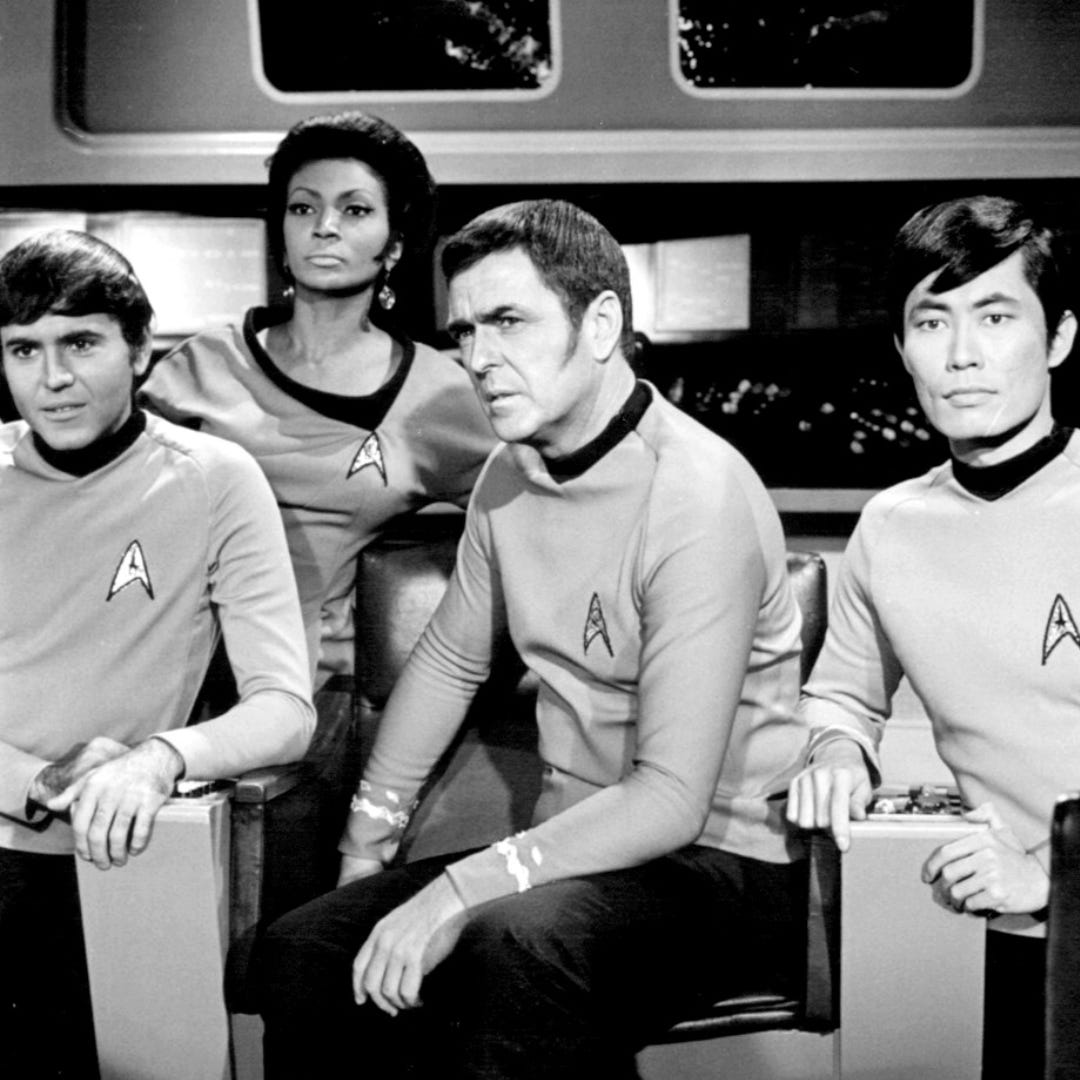  The crew of the enterprise in uniform stares out tensely as they await for news of their fate. 