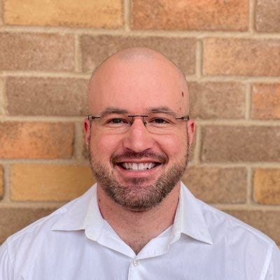 The twitter profile photo of Kevin Bass - a bald white man smiling.