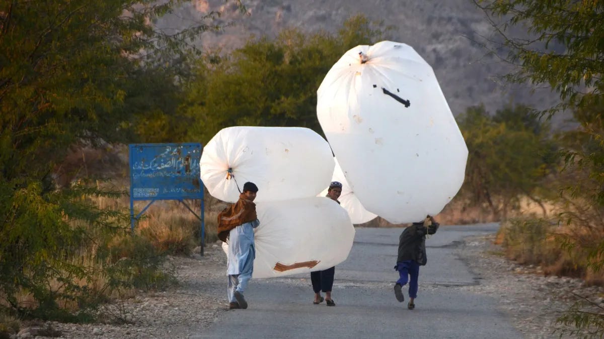 Local's carry the natural gas stored in a plastic balloons at Banda Davud Shah town in Khyber Pakhtunkhwa, Pakistan on January 09, 2023.