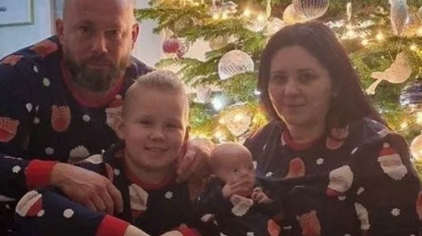 Lucy Wilk and her family by a Christmas tree in matching Santa and reindeer pyjamas