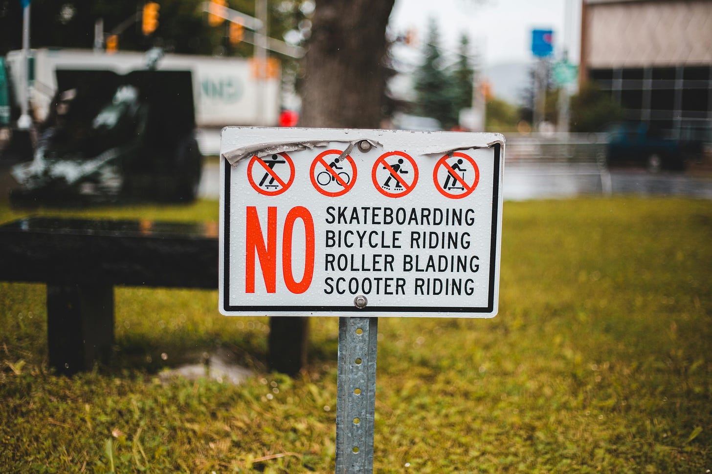 A sign in a park telling people they can't do anything like ride a bike or skateboard