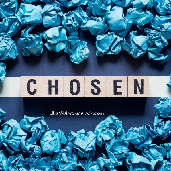 Balls of blue crumpled paper surrounds wooden blocks that spell "Chosen"