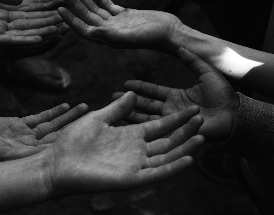 a group of people holding their hands together a group of people holding their hands together
