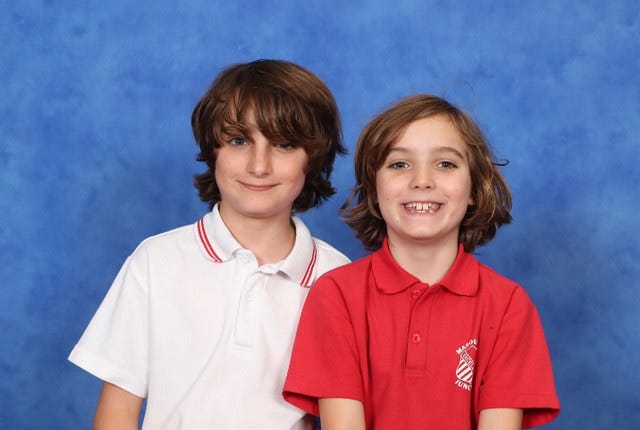 A school picture with Wiley to the left in a white polo and Nathaniel on the right in a red polo, both with longish hair, Nathaniel with impish grin and Wiley more reserved with dimples.