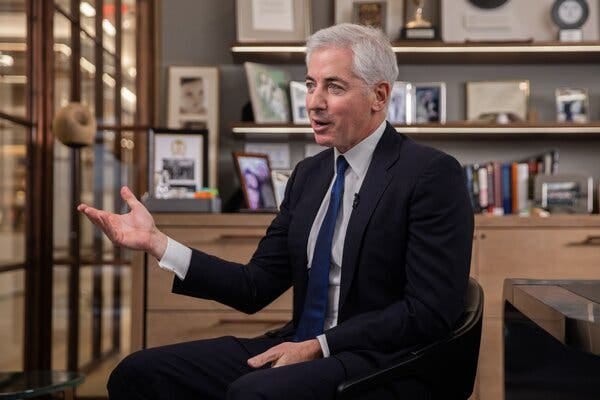 Mr. Ackman gestures with his right hand while sitting and speaking in an office.
