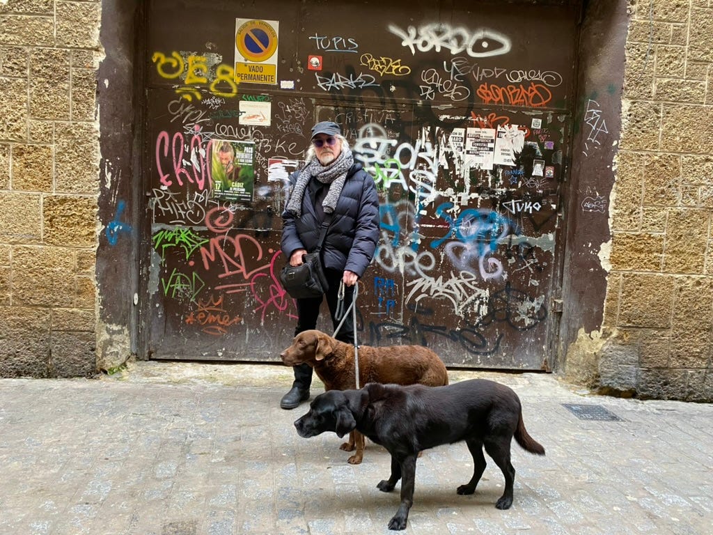 Simon Campbell and two labrador hounds with graffiti behind