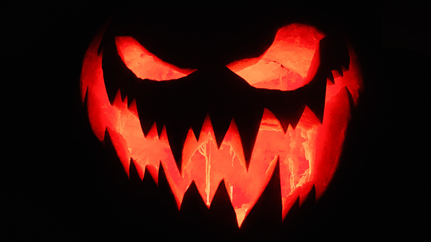 What are you afraid of? 10 common writing fears. Image shows a scary carved Halloween pumpkin face, glowing against a black background.