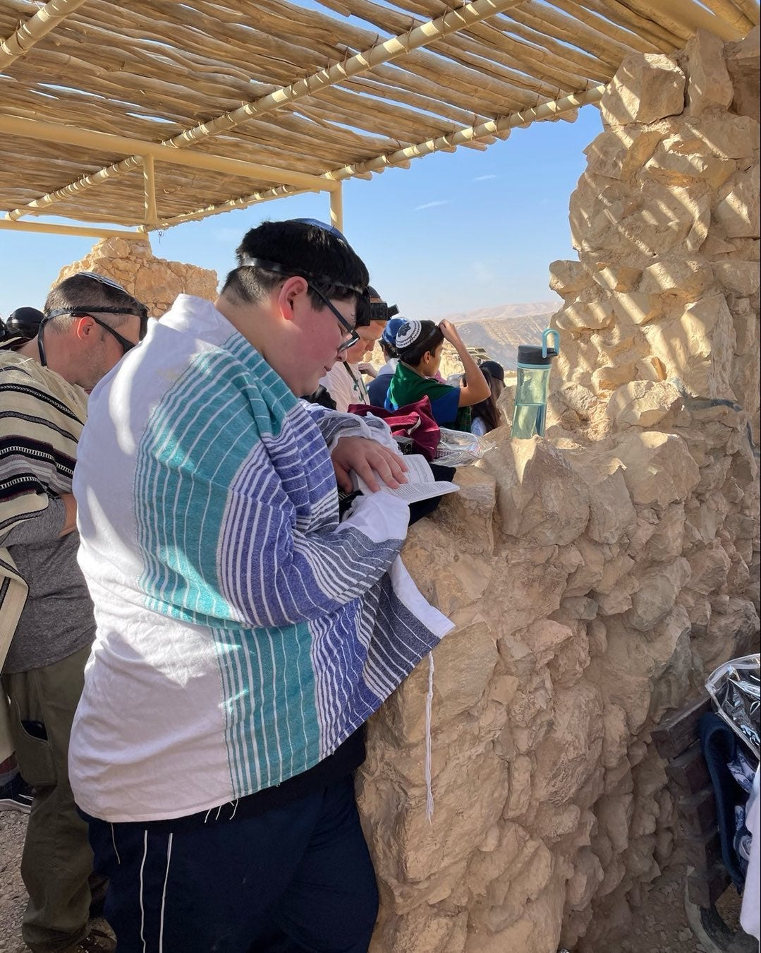 The author wears a tallit and tefillin and prays