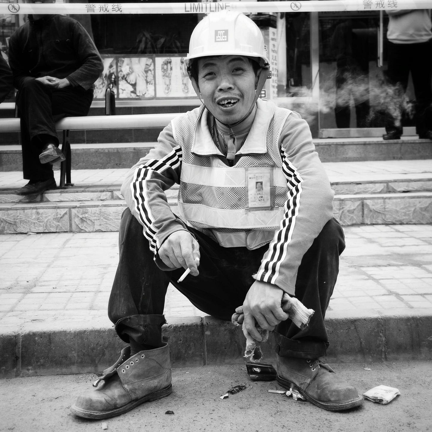 Migrant worker taking a break on a sidewalk in Beijing.