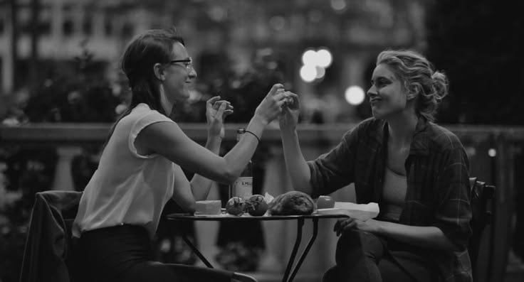 This may contain: two women sitting at a table eating food