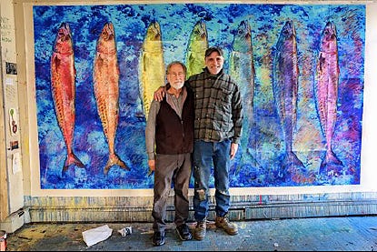 Two men standing in front of a painting of fish

Description automatically generated