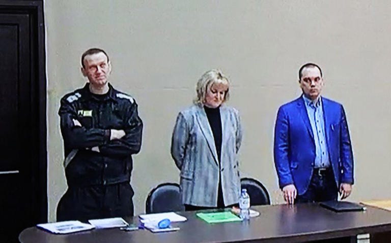 FILE PHOTO: Russian opposition leader Alexei Navalny, accused of fraud and contempt of court, his lawyers Olga Mikhailova and Vadim Kobzev are seen on a screen via a video link during a court hearing at the IK-2 corrective penal colony in the town of Pokrov in Vladimir Region, Russia March 22, 2022. REUTERS/Evgenia Novozhenina/File Photo