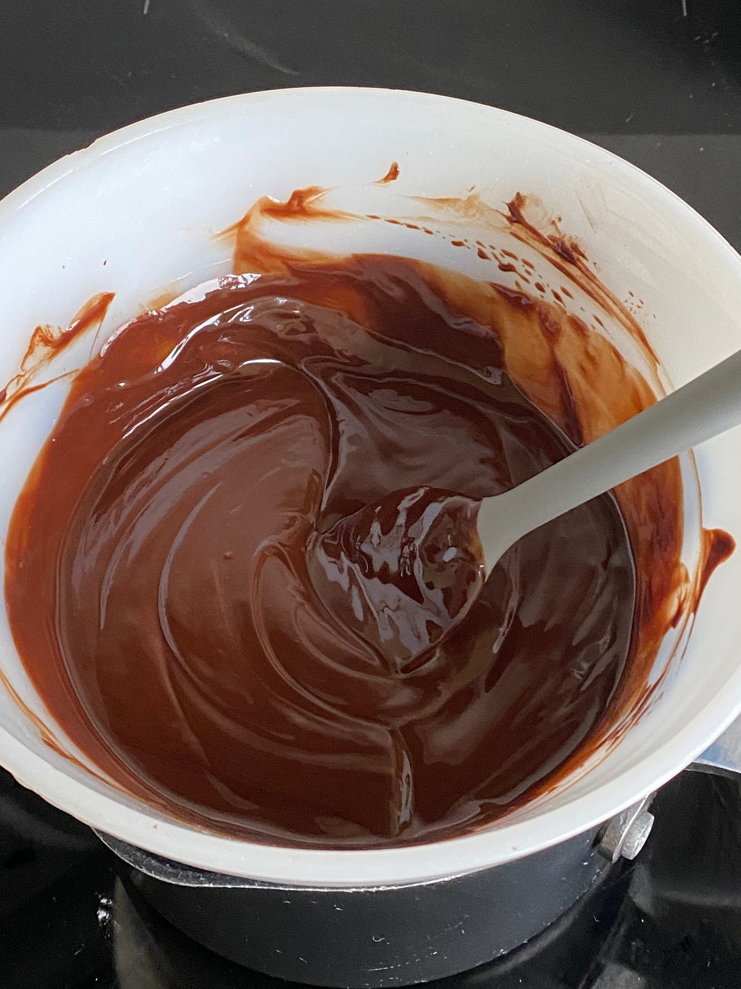 Melted chocolate in a dish and spread over a cake. 