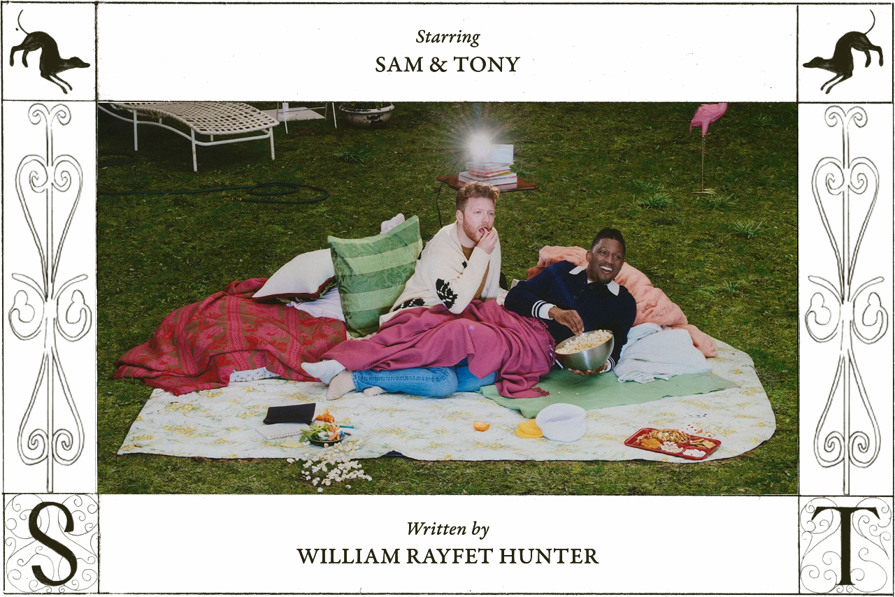 Sam and Tony recline on a grassy lawn under blankets, watching a film projected behind the camera. The scene is framed like a movie credit, reading “Starring Sam & Tony” and “Written by William Rayfet Hunter,” with sketches of greyhounds and ornate initials S and T.
