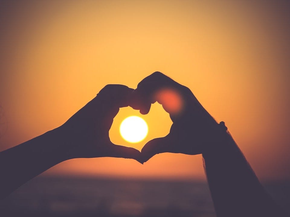 silhouette of person's hands forming heart