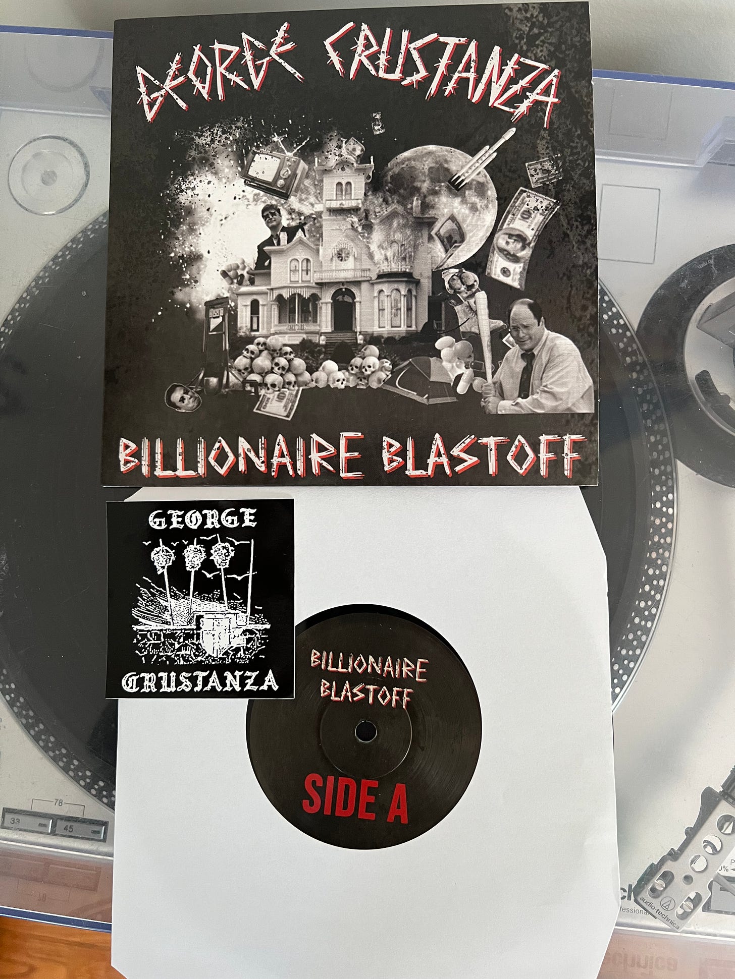 a record by George Crustanza, called Billionaire blastoff, and a sticker featuring heads on pikes.