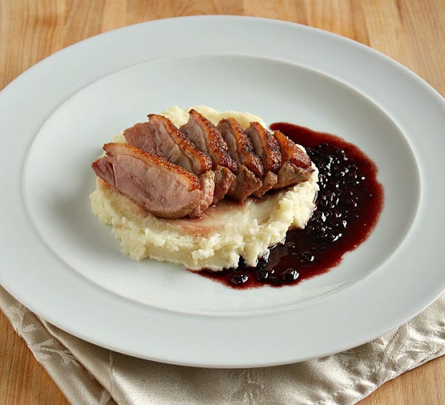 Glutenfree seared duck breast on mashed potato with redcurrant sauce